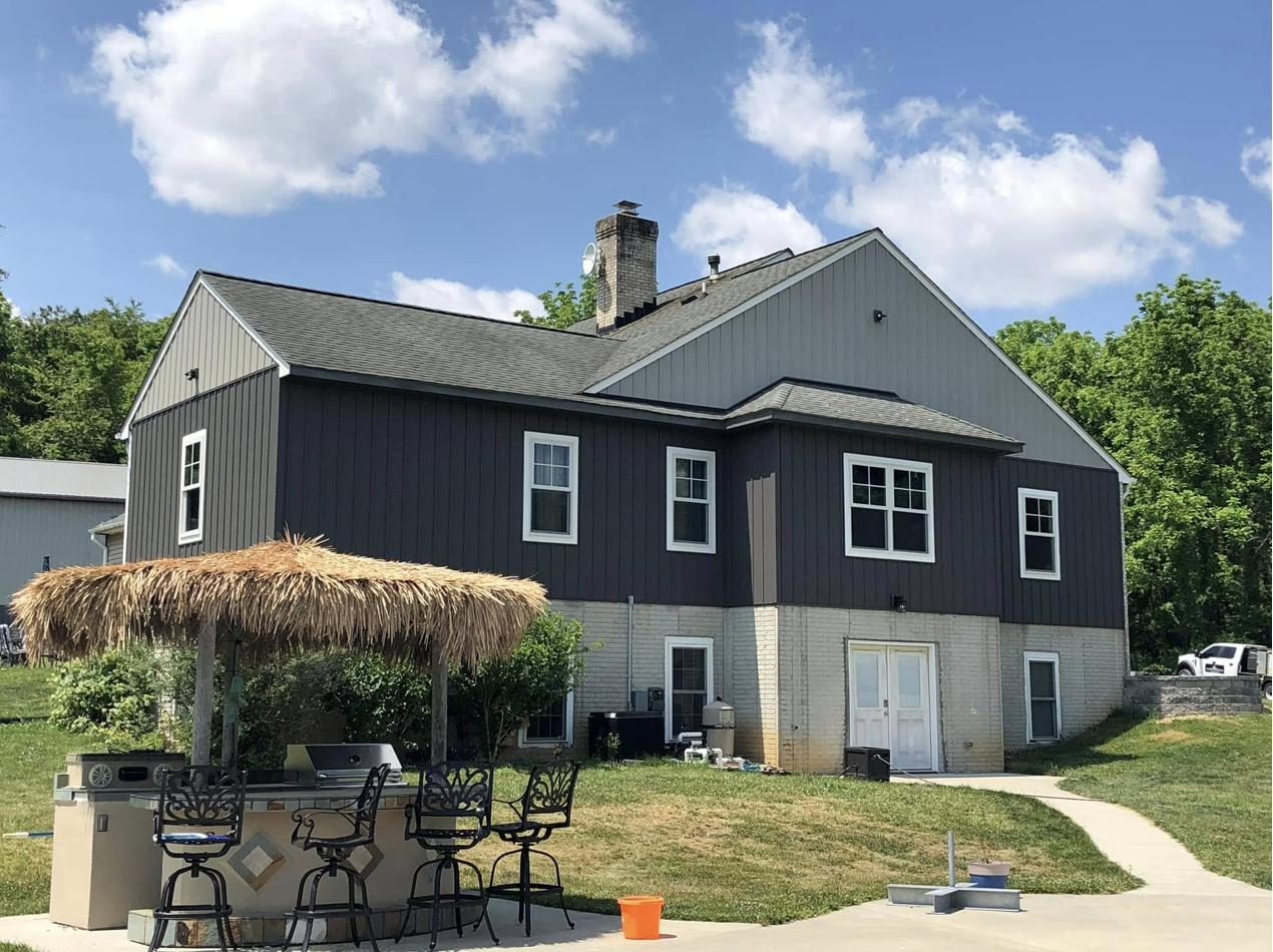 Black barndominium with cupolas and wraparound porch in Maryland