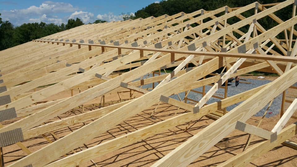 Engineered roof trusses on a post-frame building under construction by Pole Buildings Plus