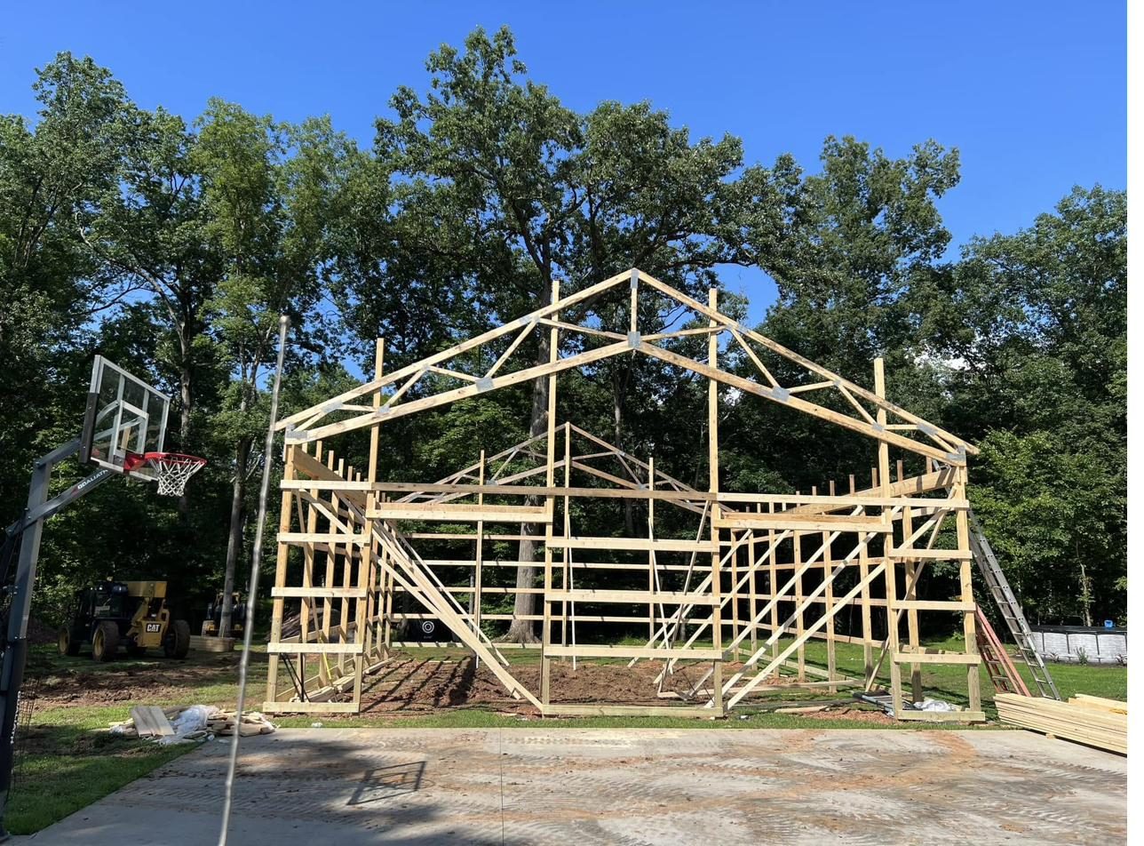 Post-frame pole building under construction showing engineered roof trusses in Maryland
